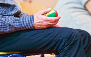 Man holding a hand therapy ball exploring the benefits of occupational therapy