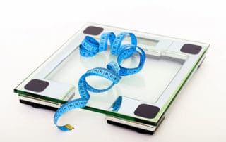 photo of tape measure and scales representing the impact of obesity on joint health