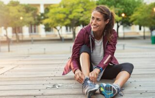 woman tying shoes getting into running form