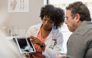 Female physician assistants in orthopaedics explaining an x-ray to a patient