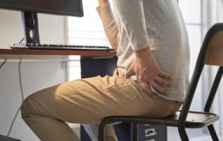 man in a chair experiencing hip pain from sitting