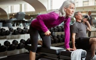 Fit, mature couple working out in a gym demonstrating strength training for seniors