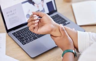 woman holding her wrist in pain from carpal tunnel syndrome