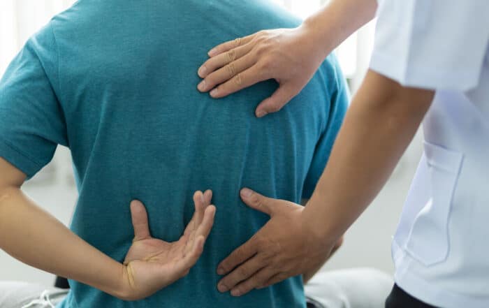 A man with back pain sees an orthopedic surgeon, so the doctor is diagnosing the man's back pain.