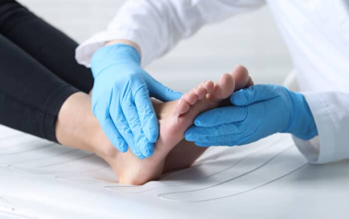 Foot and ankle doctor examining patient's foot in hospital.