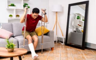 Young man recovering from broken leg injury at home.