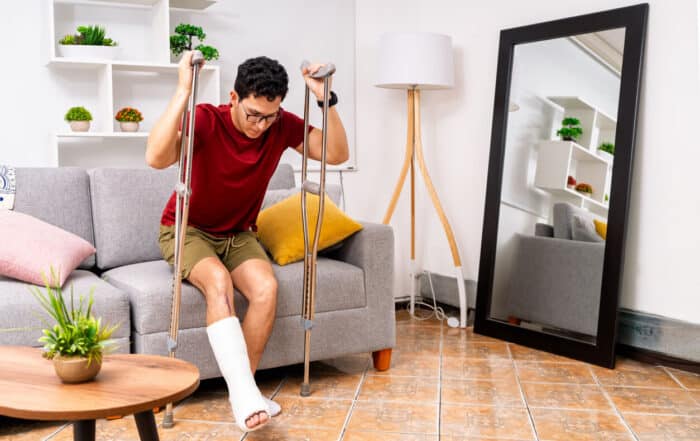 Young man recovering from broken leg injury at home.
