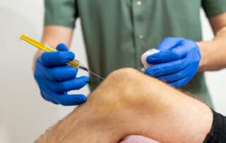 Doctor hand holding syringe PRP for injection to knee for treating knee pain.