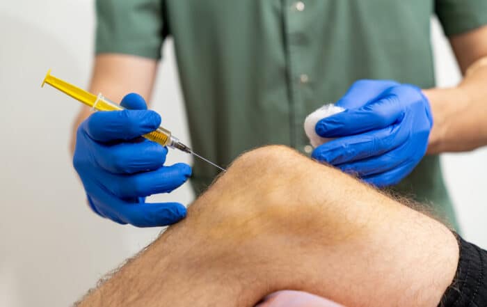 Doctor hand holding syringe PRP for injection to knee for treating knee pain.