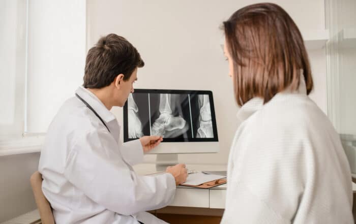 Young male orthopedist explain to the woman patient.